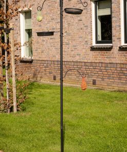 vogelvoerhouder met waterschaaltjes, strooivoer, zaden en vetbollen in tuin.