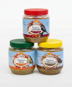 Drie potten vogelvoer pindakaas met verschillende smaken.