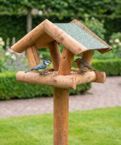 Vogels eten uit paalvoederhuis met groen dakleer
