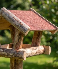 Paalvoederhuis met rood dakleer in de tuin