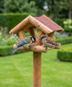 Vogels eten uit paalvoederhuis met rood dakleer
